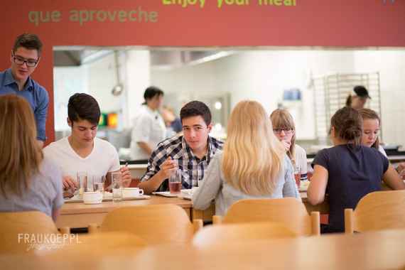 schuelerinnen und schueler in der mittagspause im speisesaal beim essen