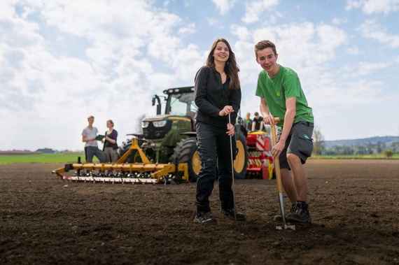 schuelerin und schueler auf einem feld