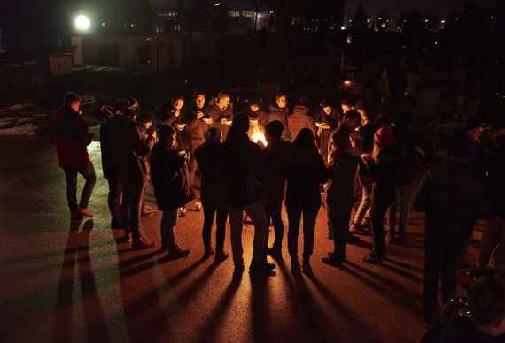 schuelerinnen und schueler am abend der adventbesinnung vor einem lagerfeuer