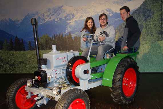 schuelerinnen und schueler auf einem alten steyr-traktor